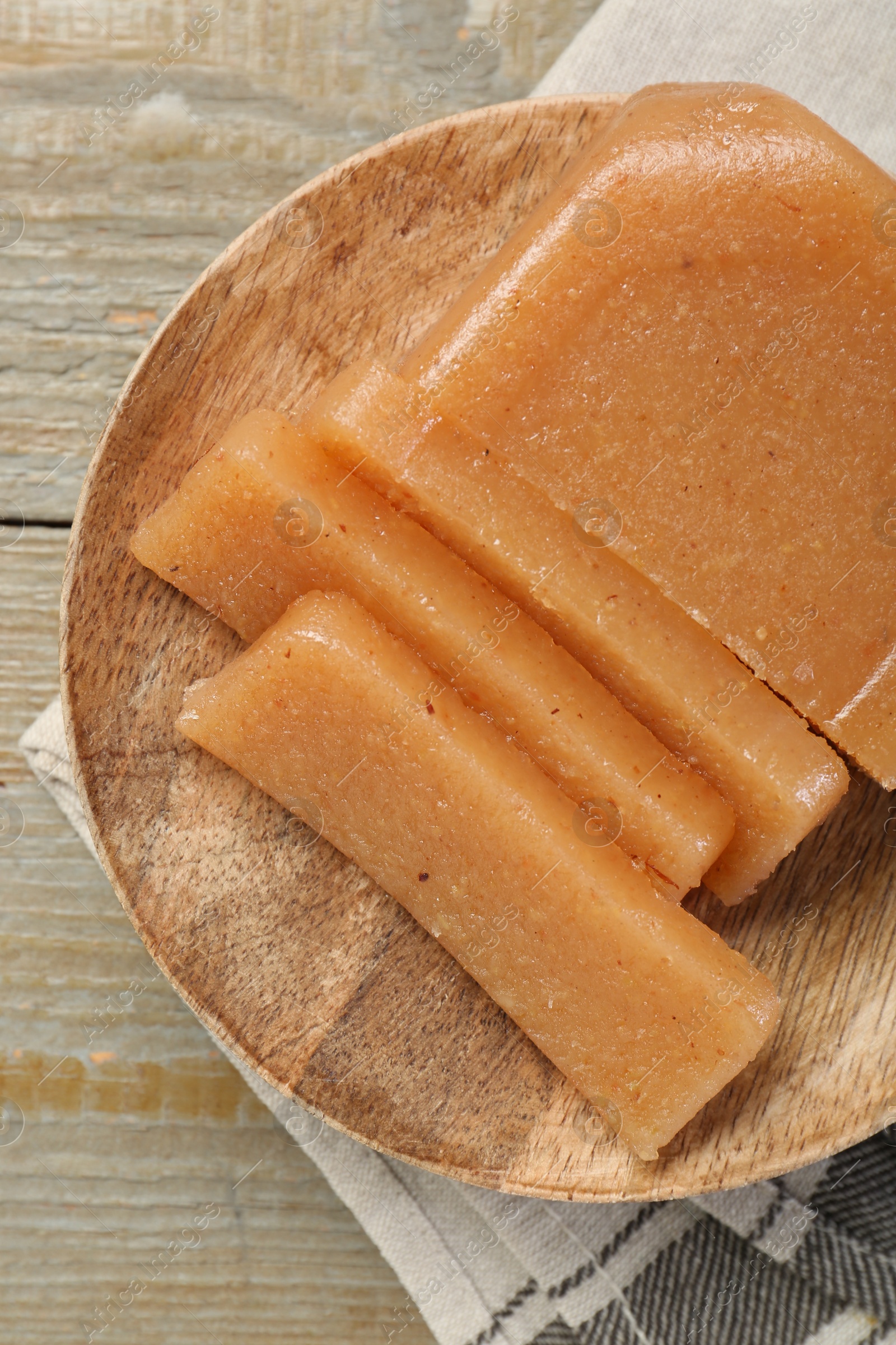 Photo of Tasty sweet quince paste on wooden table, top view