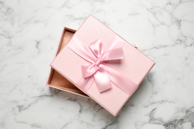 Photo of Beautiful pink gift box on white marble table, top view