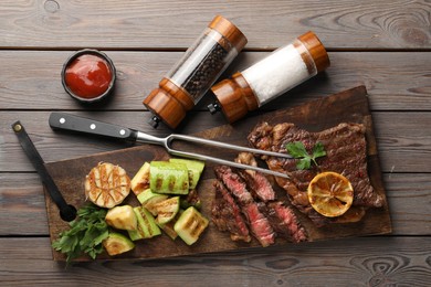 Photo of Delicious grilled beef steak and vegetables served on wooden table, flat lay