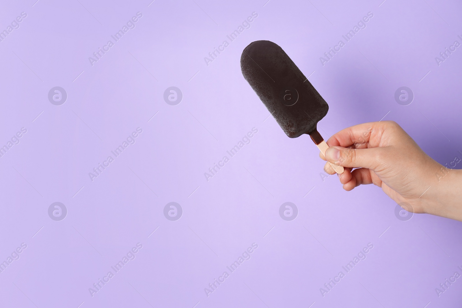 Photo of Woman holding delicious ice cream with chocolate against color background, space for text