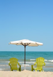 Photo of Beautiful white umbrella and chairs on sandy beach