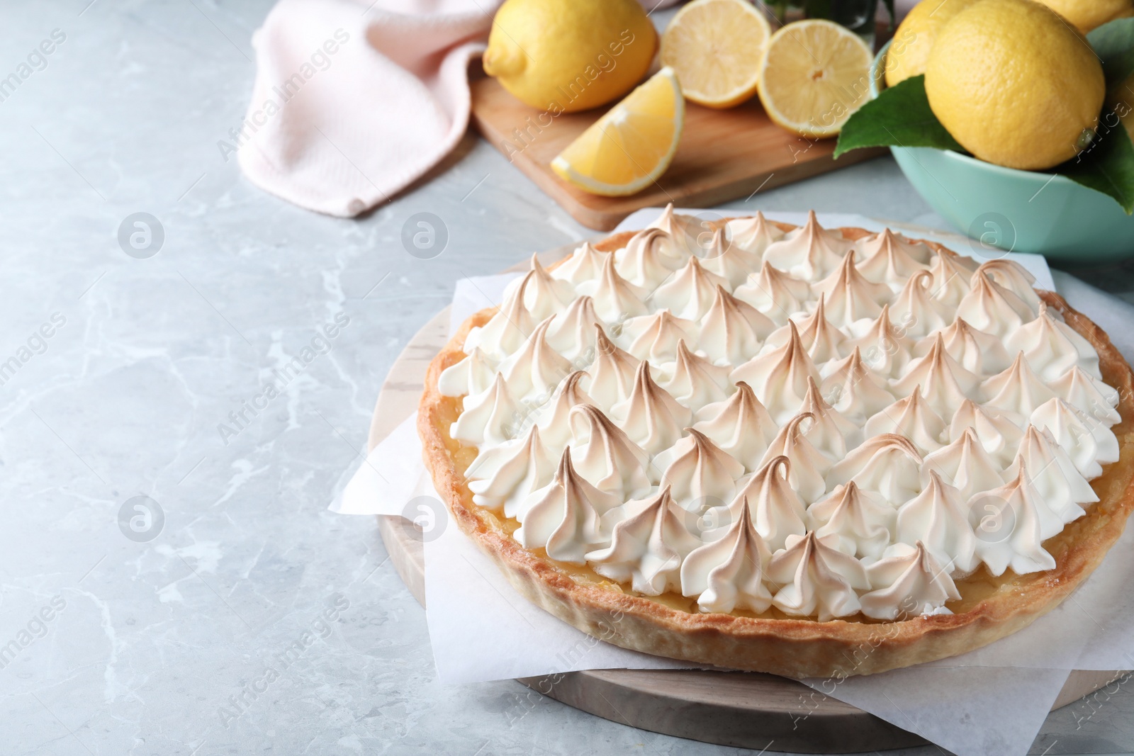 Photo of Delicious lemon meringue pie on light grey table, space for text