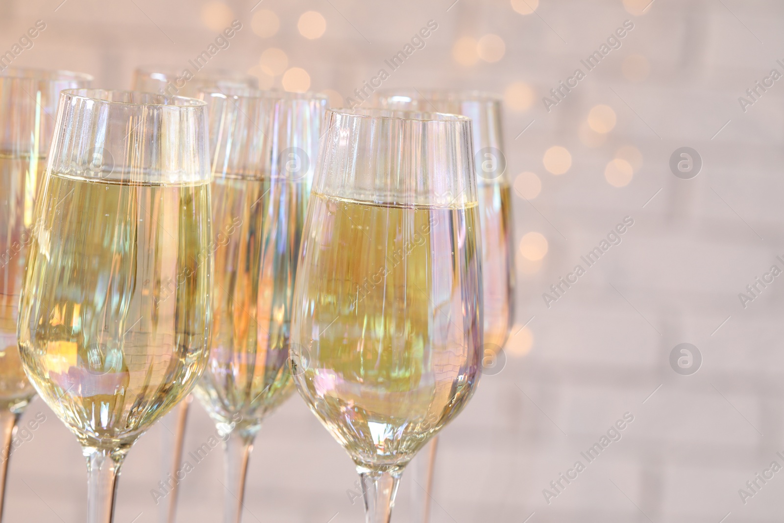 Photo of Glasses of champagne against blurred lights, closeup