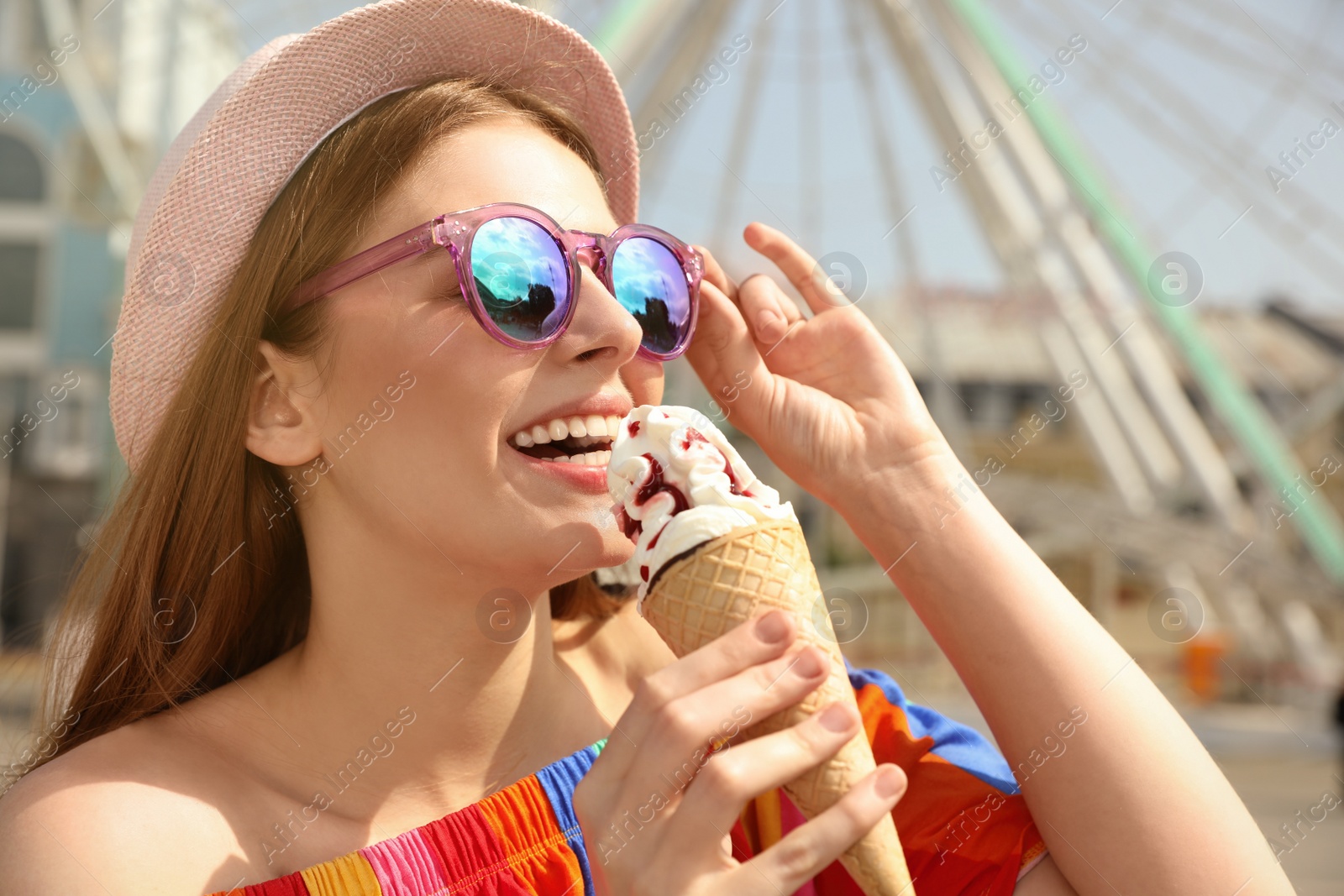Photo of Young happy woman with ice cream cone in amusement park