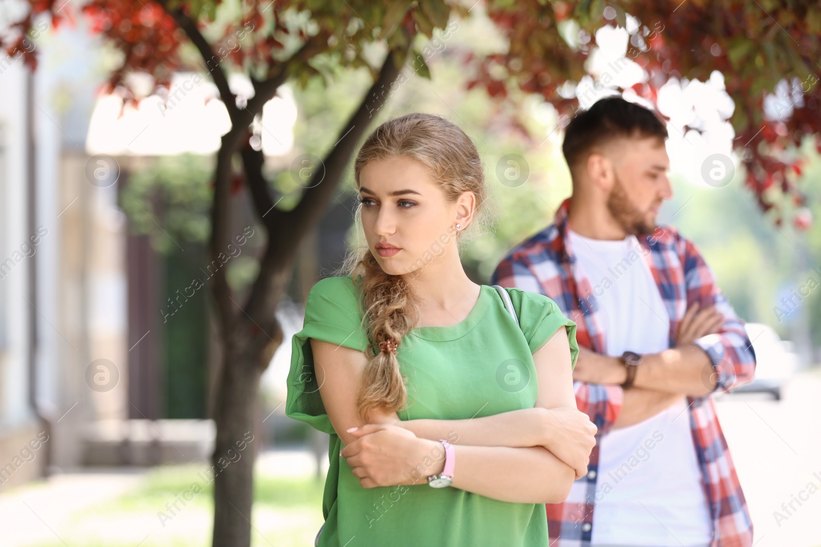 Photo of Young couple arguing on street. Problems in relationship