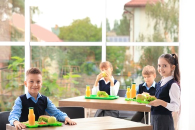 Photo of Happy children with healthy food in school canteen