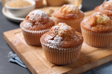 Delicious sweet muffins on black table, closeup