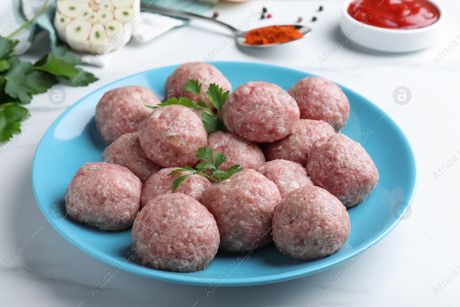 Photo of Many fresh raw meatballs on white table