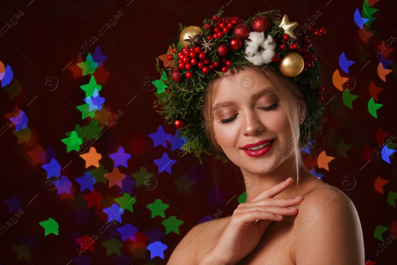 Photo of Beautiful young woman wearing Christmas wreath on blurred background. Bokeh effect