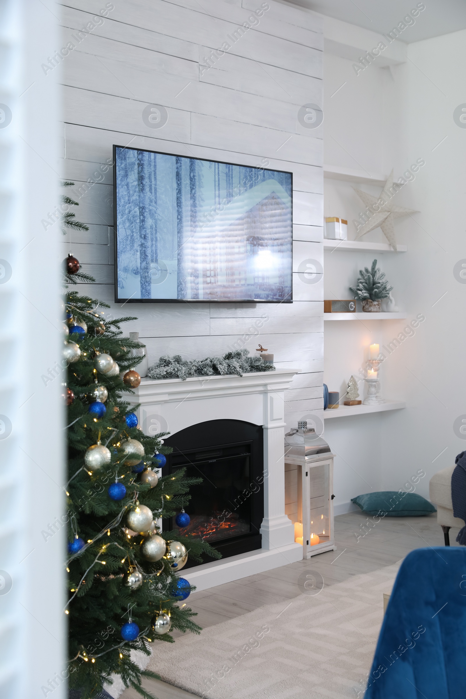 Photo of Stylish living room interior with modern TV, fireplace and Christmas tree