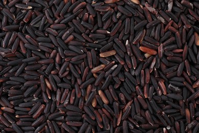 Raw black rice as background, top view