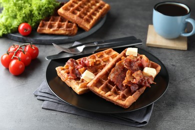 Tasty Belgian waffles served with bacon, butter and coffee on grey table
