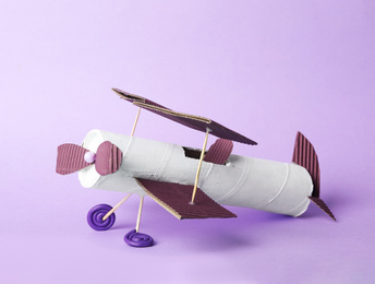 Photo of Toy plane made of toilet paper hub on lilac background