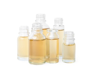 Photo of Glass bottles of essential oils on white background