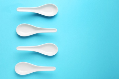 Miso soup spoons on blue background, flat lay. Space for text