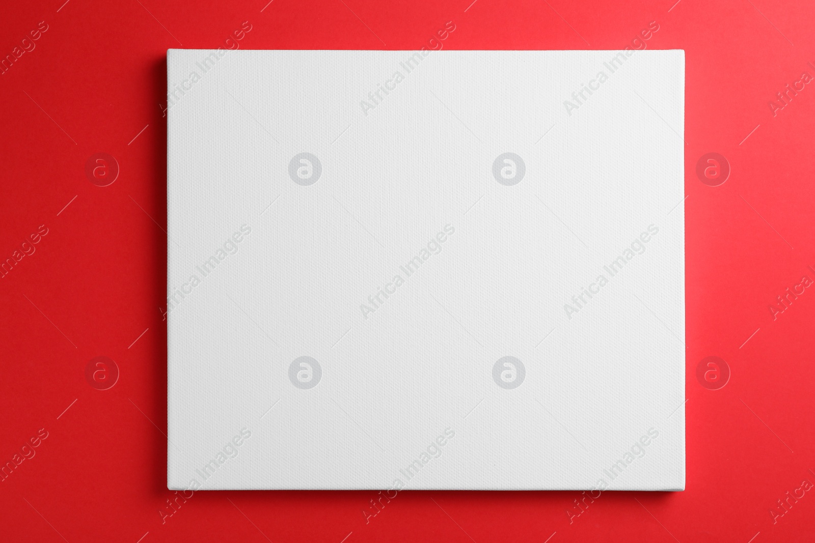 Photo of Blank canvas on red background, space for text