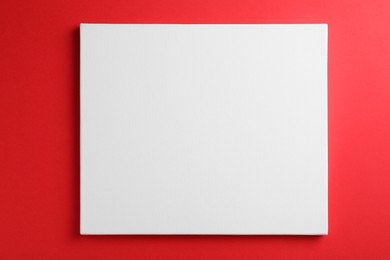 Photo of Blank canvas on red background, space for text