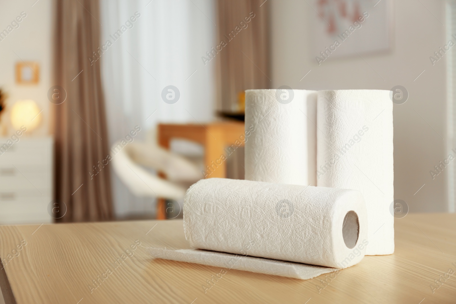 Photo of Rolls of paper towels on table indoors. Space for text