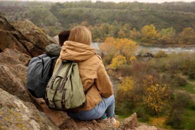 Couple of hikers with travel backpacks enjoying beautiful view of nature