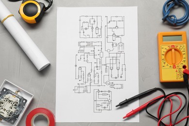 Photo of Wiring diagram, wires and digital multimeter on light grey table, flat lay