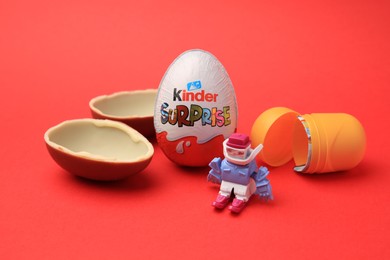Sveti Vlas, Bulgaria - June 29, 2023: Kinder Surprise Eggs, plastic capsule and toy on red background