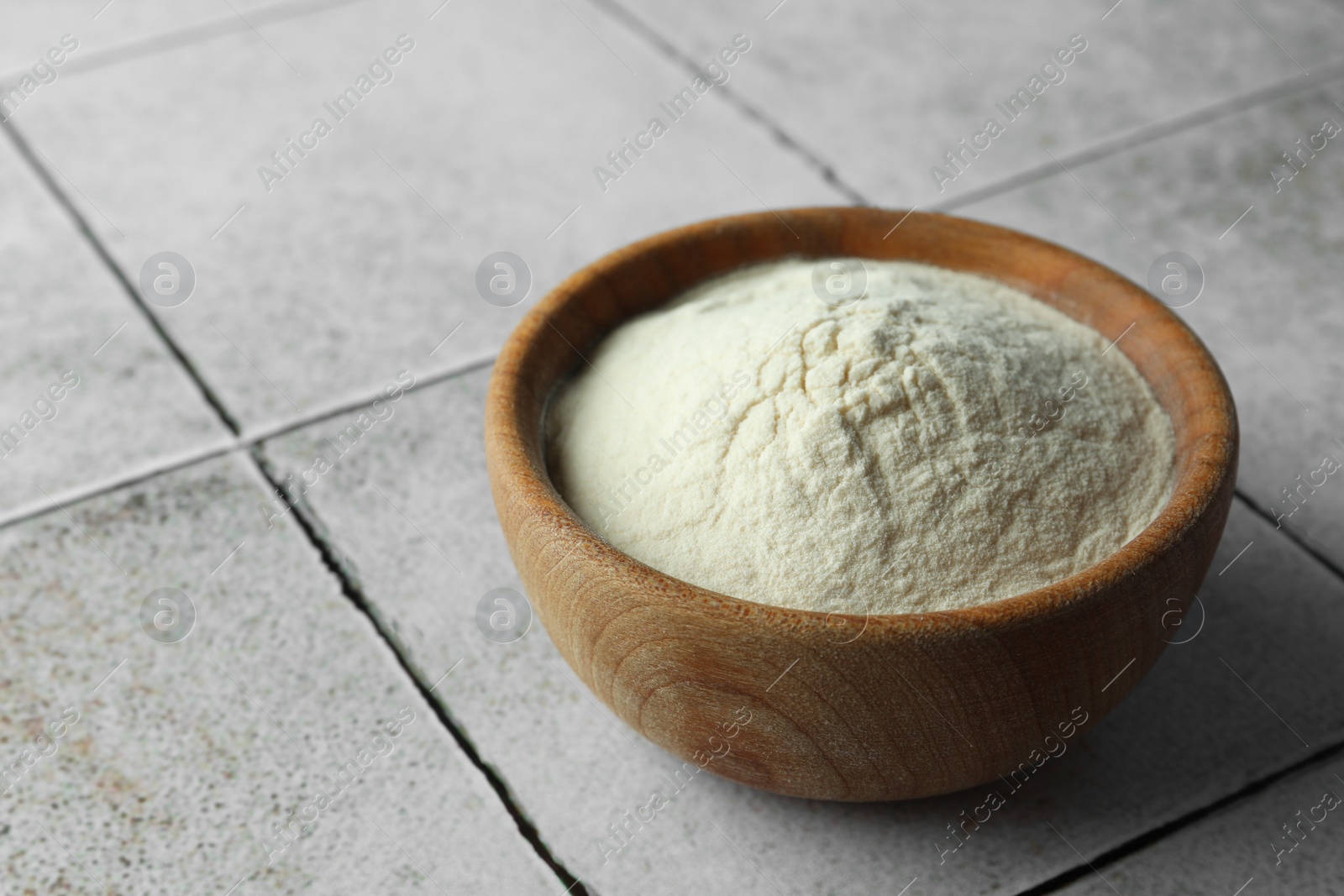 Photo of Bowl of agar-agar powder on tiled table, closeup