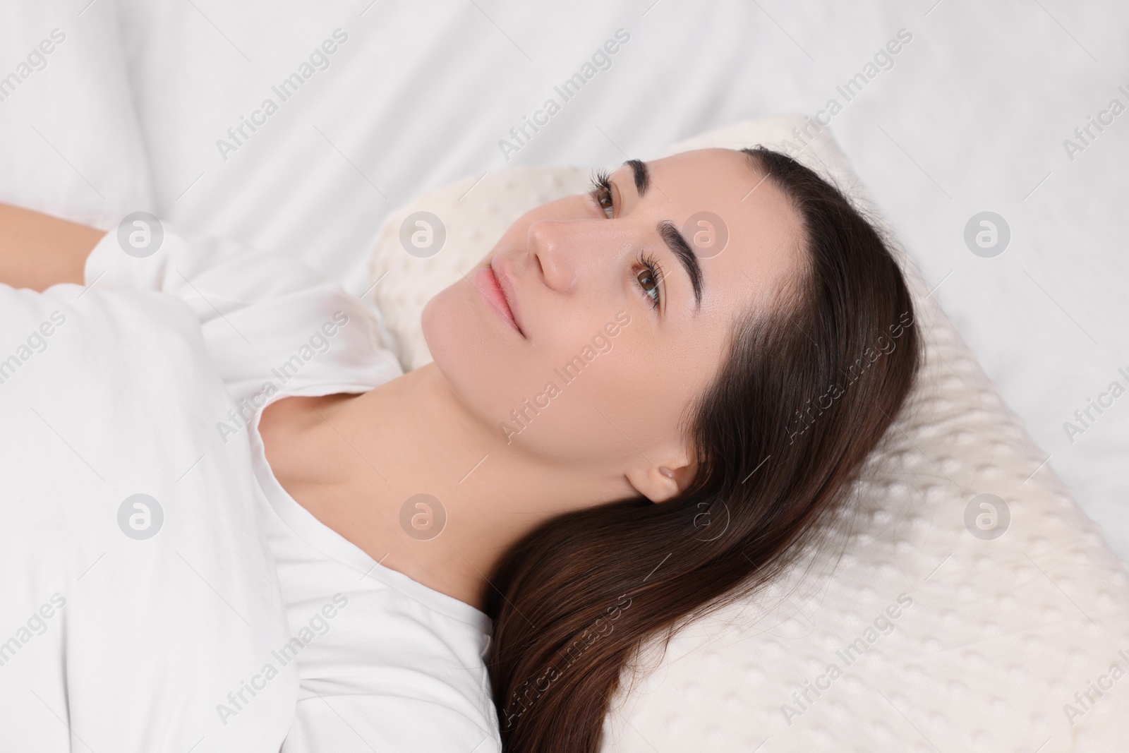 Photo of Woman lying on orthopedic pillow in bed