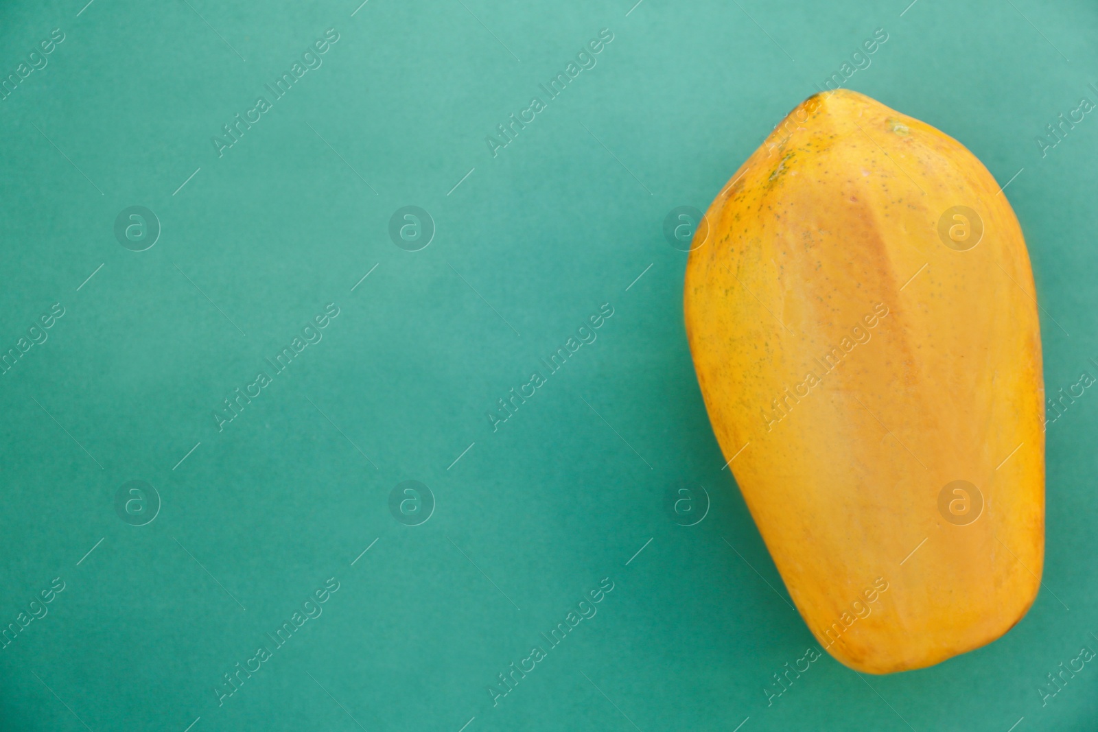 Photo of Fresh ripe papaya fruit on light blue background, top view. Space for text