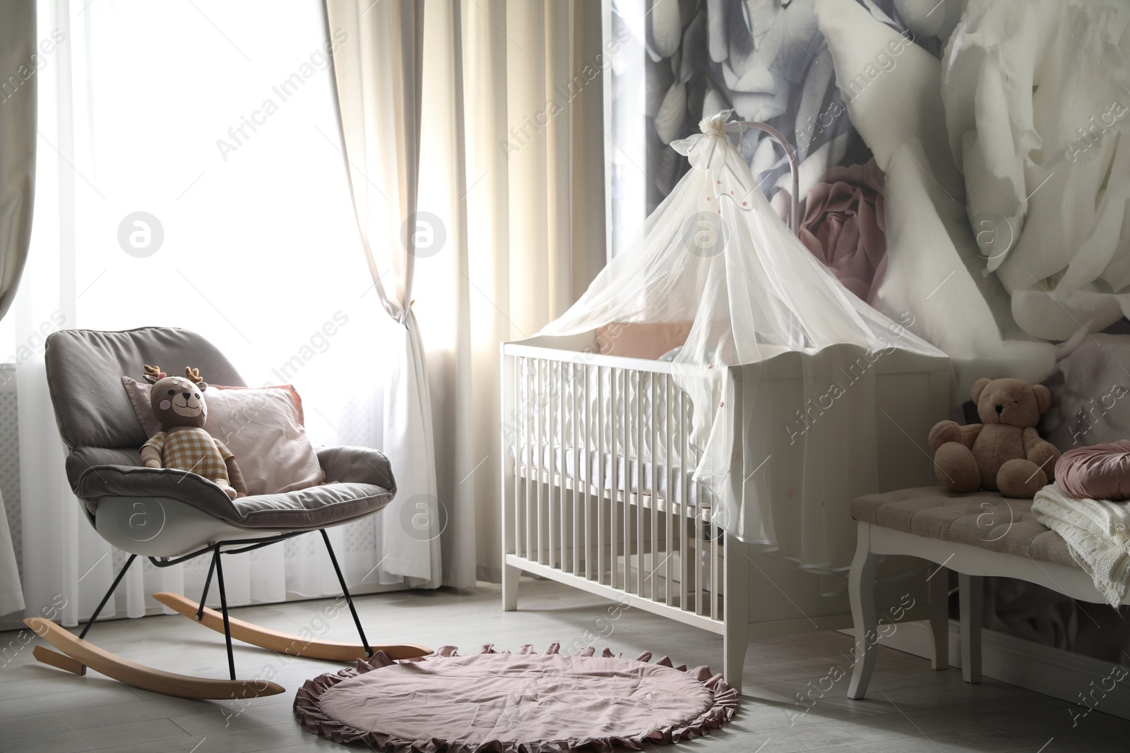 Photo of Baby room interior with stylish crib and floral wallpaper