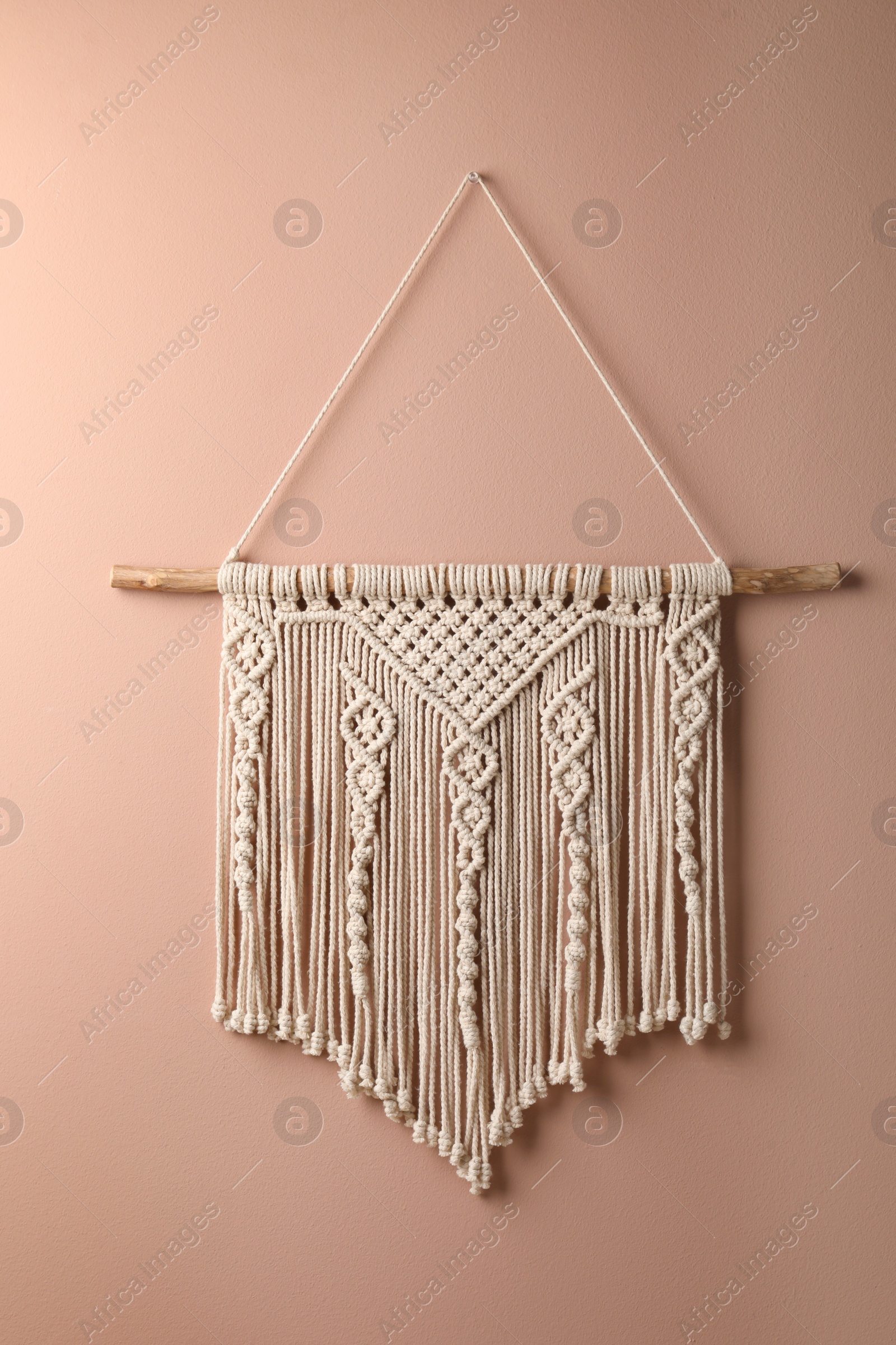 Photo of Stylish white macrame hanging on pink wall