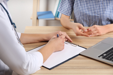 Photo of Doctor consulting patient in clinic, closeup. Medical service