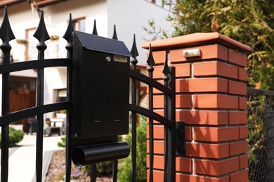 Black metal letter box on fence outdoors