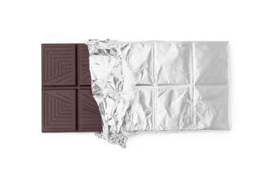 Photo of Delicious dark chocolate bar wrapped in foil isolated on white, top view