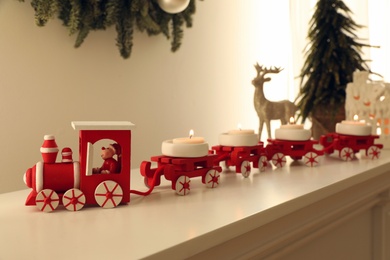 Photo of Red toy train as Christmas candle holder on shelf