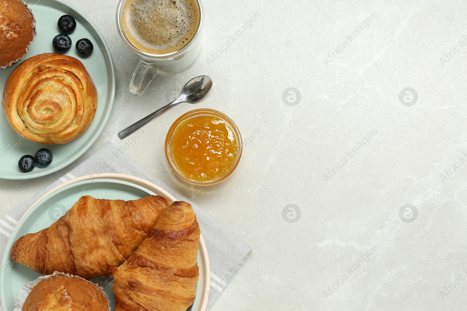 Photo of Delicious breakfast with tasty bun, croissants and coffee on white table, flat lay. Space for text