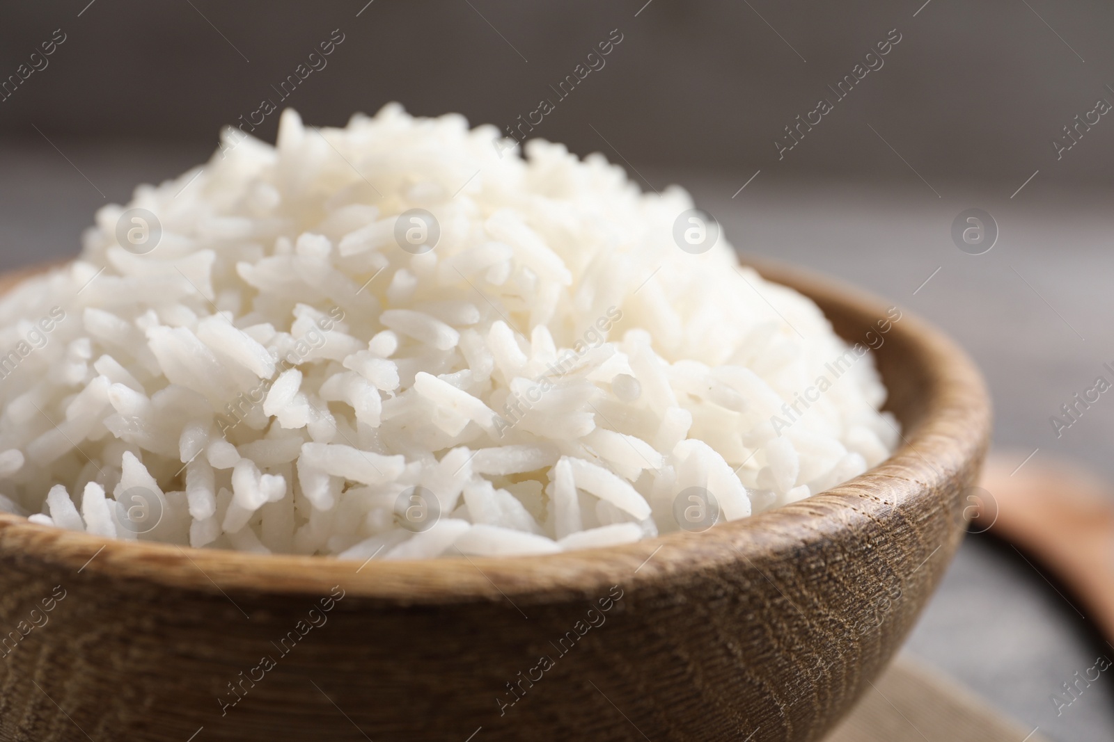 Photo of Bowl of tasty cooked white rice on table, closeup