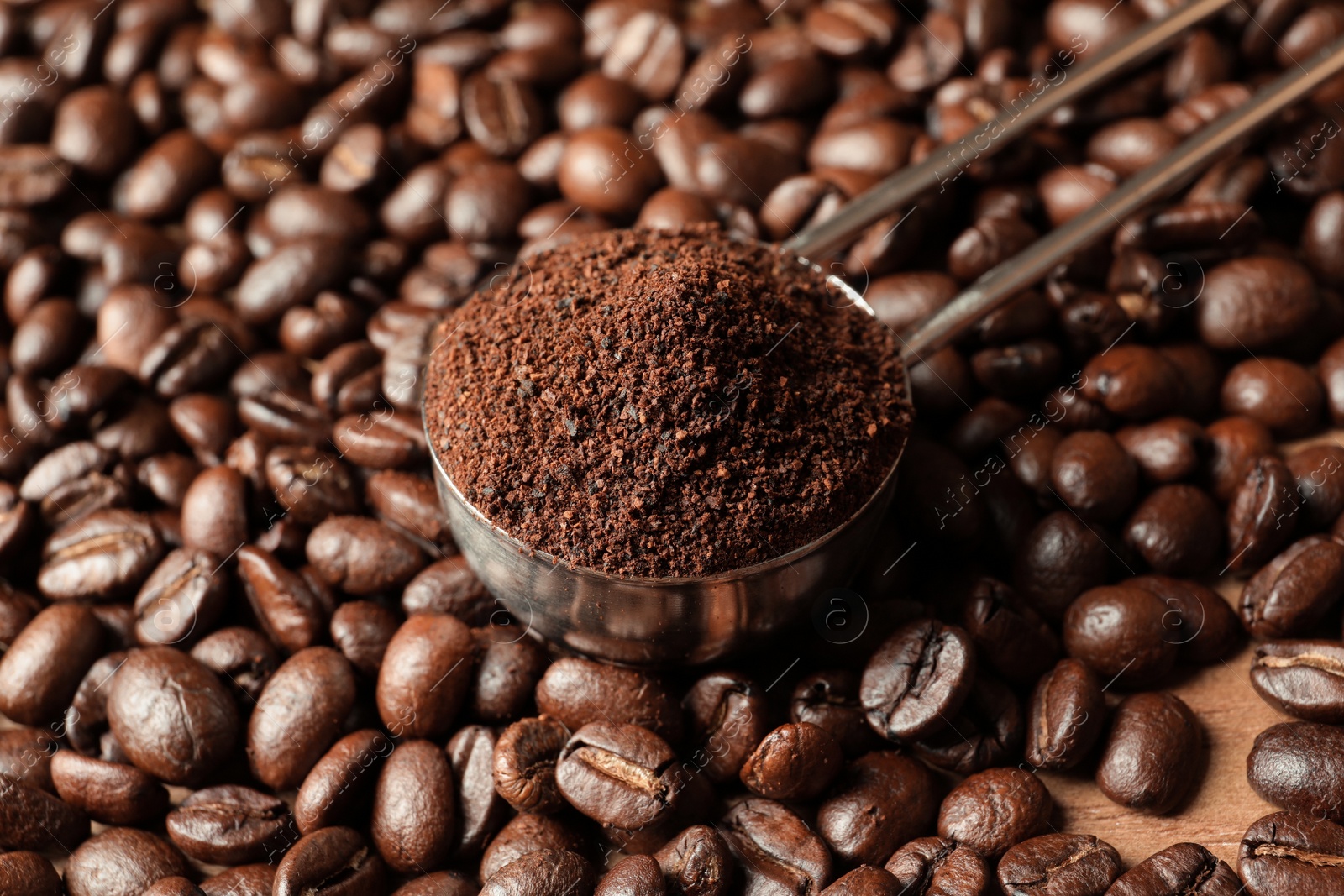 Photo of Spoon with coffee grounds and roasted beans, closeup