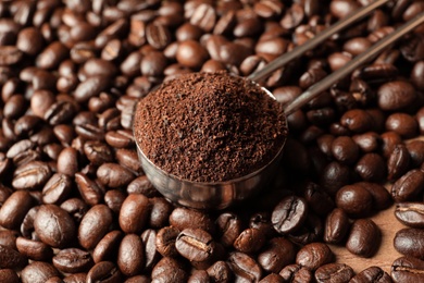 Photo of Spoon with coffee grounds and roasted beans, closeup