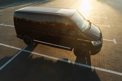 Black van on parking lot at sunset outdoors