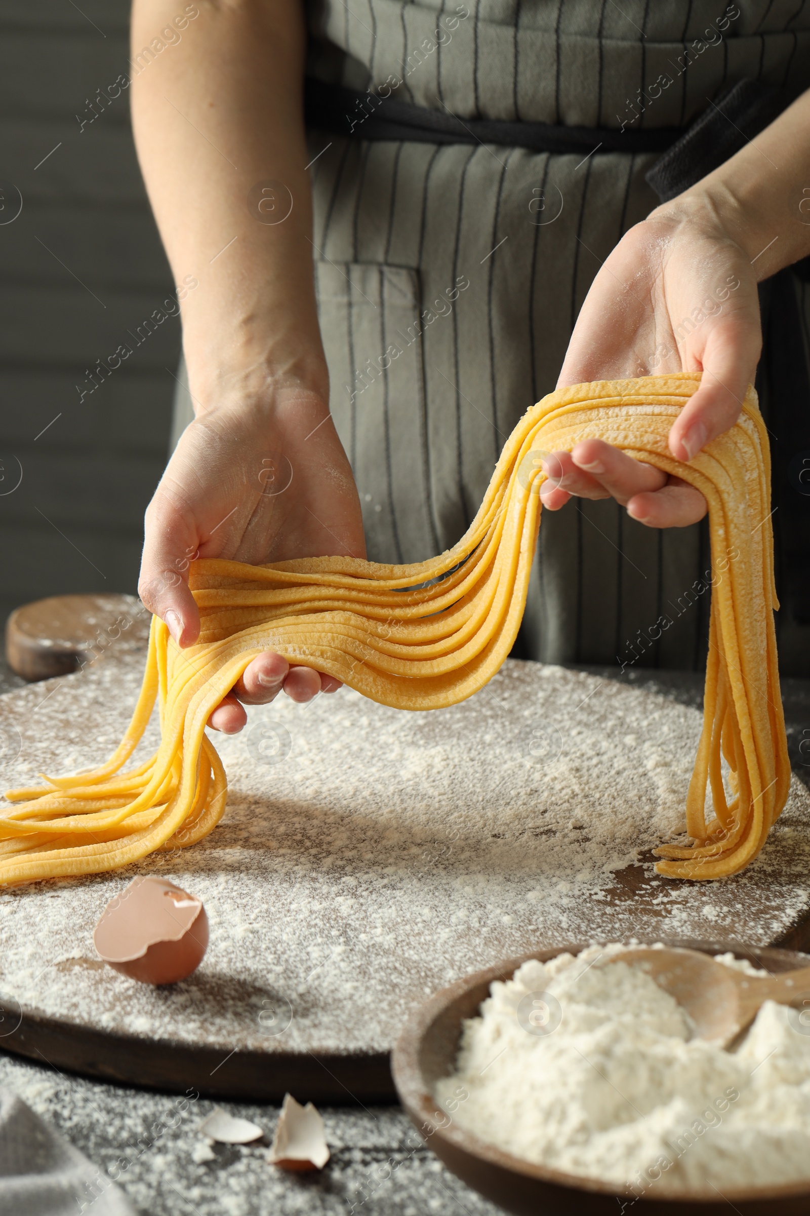 Photo of Woman making homemade pasta at table, closeup