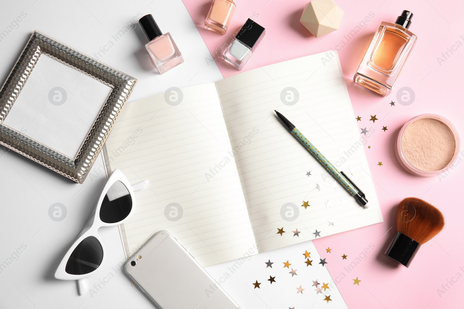 Photo of Flat lay composition with blank notebook, cosmetics and phone on color background, space for text. Blogger's workplace