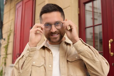 Photo of Portrait of handsome bearded man in glasses outdoors