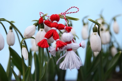 Fresh blooming snowdrops and traditional martisor outdoors. Spring flowers
