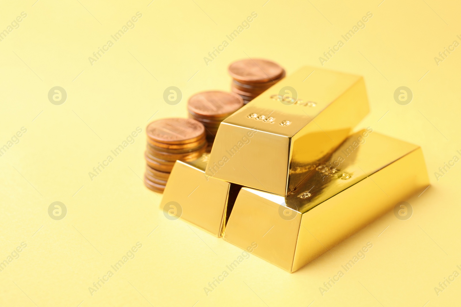 Photo of Shiny gold bars and coins on color background