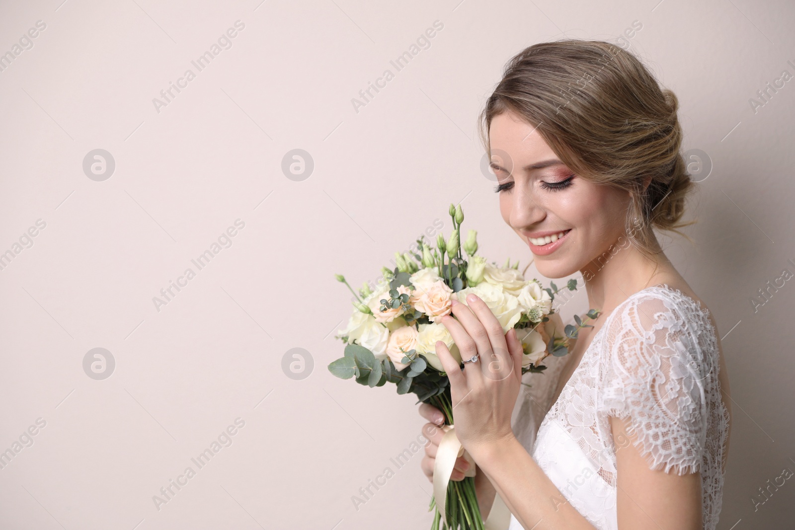 Photo of Young bride with beautiful wedding bouquet on beige background. Space for text