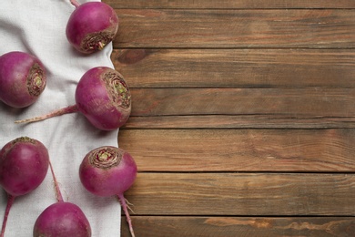 Photo of Red turnips on wooden table, flat lay. Space for text