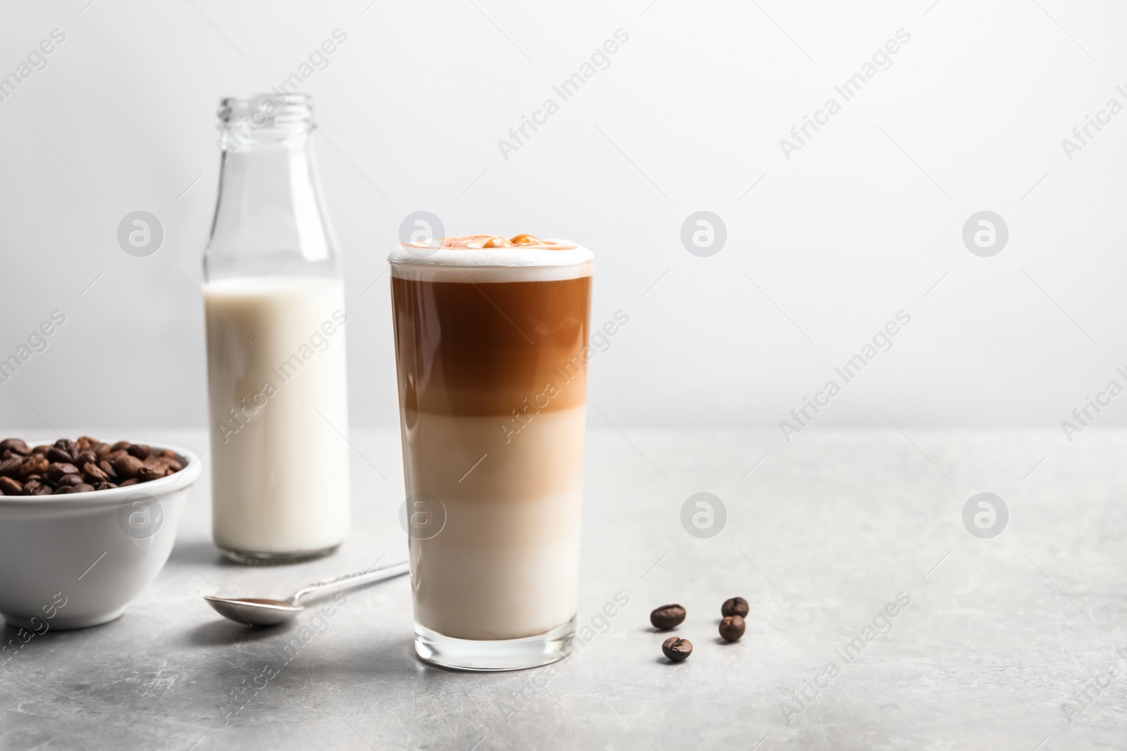 Photo of Glass with delicious caramel latte on table