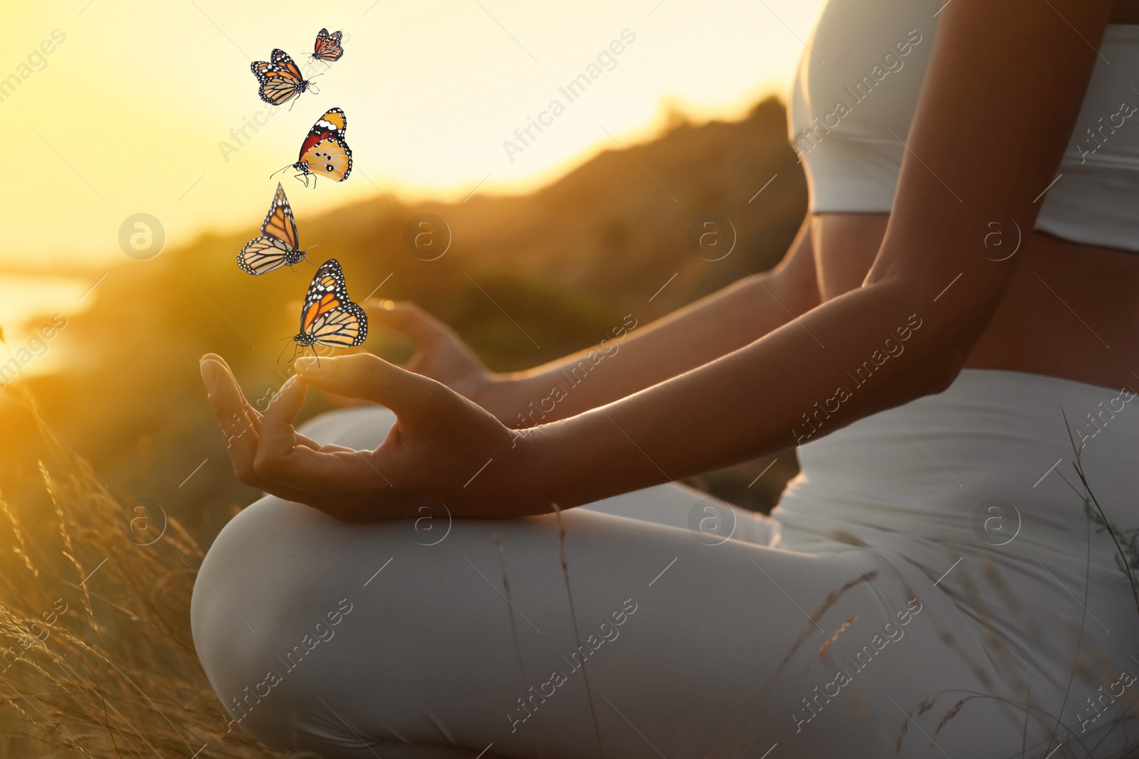 Image of Woman meditating outdoors at sunset, closeup view