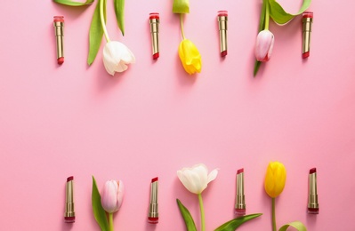 Photo of Flat lay composition with different lipsticks and tulip flowers on color background, space for text