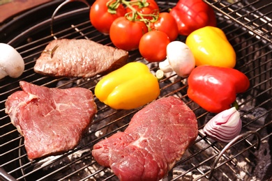 Photo of Modern grill with meat and vegetables outdoors, closeup